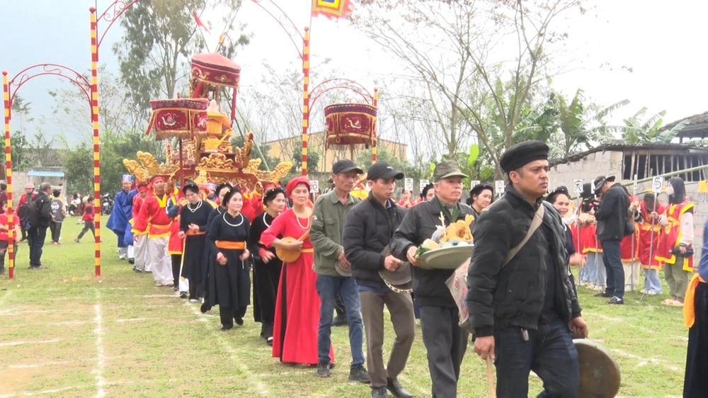 Procession traditionnelle des habitants lors de la fête du Lồng Tồng avec mâm d'offrandes, instruments de musique et palanquin sacré.