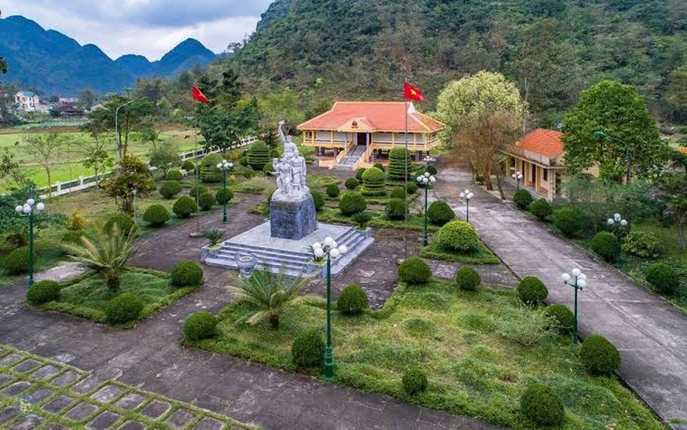 Vue aérienne du musée de l'Insurrection de Bắc Sơn abritant une statue commémorative au milieu d'un jardin paysager au pied des montagnes.