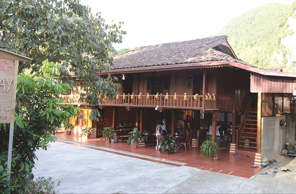 Une grande maison sur pilon traditionnelle en bois servant d'hébergement chez l'habitant (homestay) pour les visiteurs à Quỳnh Sơn.