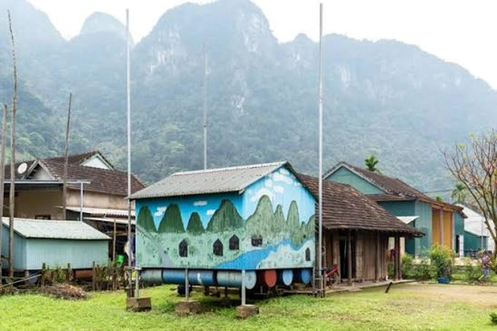 Maison flottante anticrue peinte de fresques colorées dans le village de Tan Hoa, au pied des montagnes karstiques.