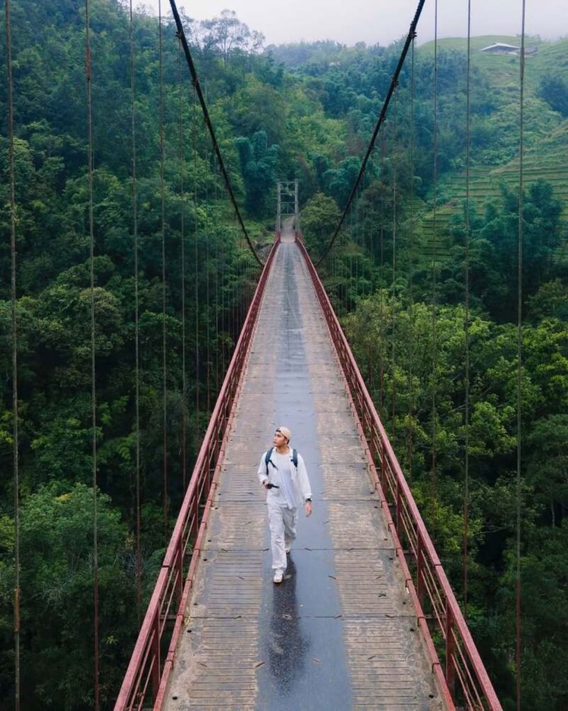 Le pont suspendu rouge se tient suspendu entre terre et ciel.