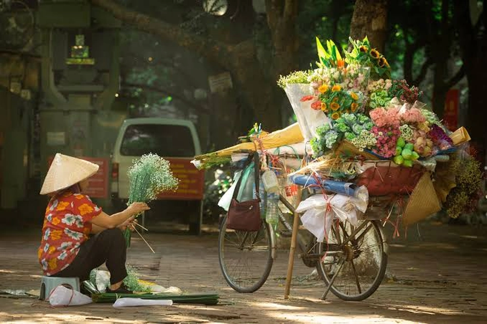 Vendeuse de fleurs ambulante à Hanoi.