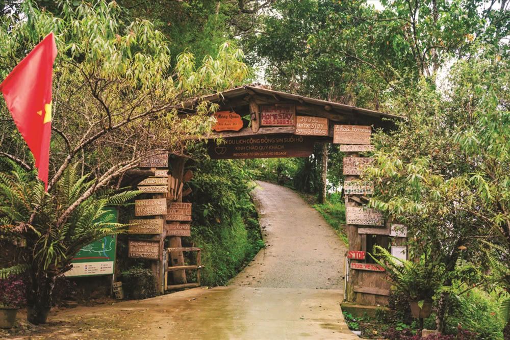 Le portique d'entrée en bois mène au paisible village touristique communautaire de Sin Suối Hồ.